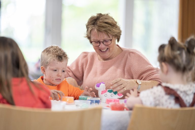 jongen-kijkt-naar-knutselwerkje_oma-lacht_2023-11-04-11.39.31-2
